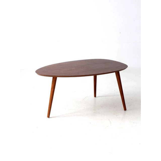 This mid-century side table showcases sculptural simplicity and an organic teardrop-shaped top in a rich walnut tone with...