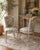 A refined pair of vintage Louis XVI style dining chairs featuring a beautifully aged painted frame and elegant, tapered...