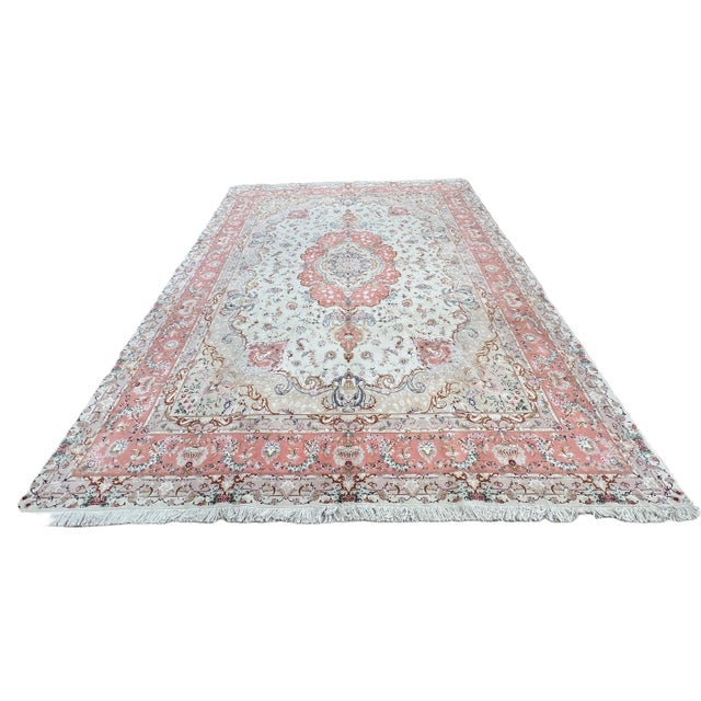 Fine Persian Tabriz rug, hand knotted in Iran with a 100% wool pile and delicate silk highlights. Measuring 9’11” x 13’2”,...