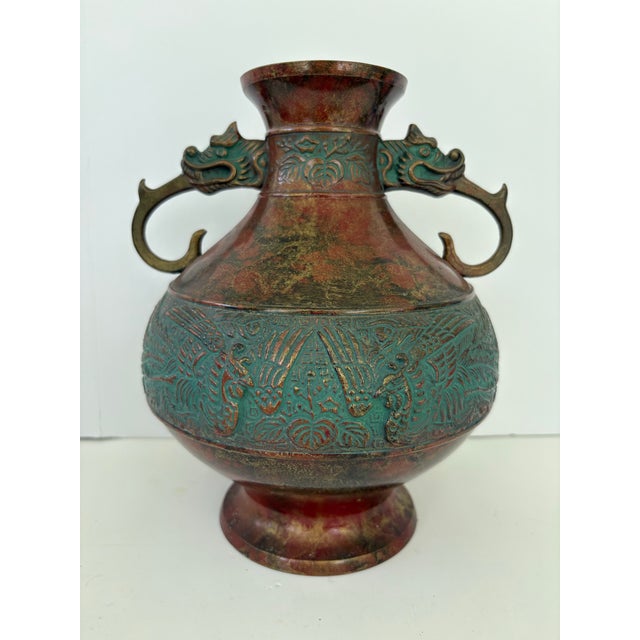 This striking vintage Japanese vase features a traditional baluster form with dramatic opposing dragon-head handles,...