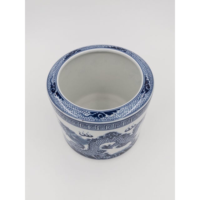 This mid-20th century blue-and-white porcelain vessel showcases a powerful hand-painted dragon in pursuit of the flaming...