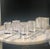 Set of four new in box lucite bud vase table setting decor. Each measures approximately 2.5” x 1.5”. Two sets available.
