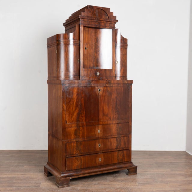 19th century Danish tall secretary bureau, crafted in mahogany with burlwood veneer. The upper section features three...