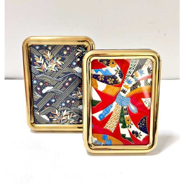 A classic pair of vintage rounded brass picture frames featuring softly curved polished brass borders and a streamlined...