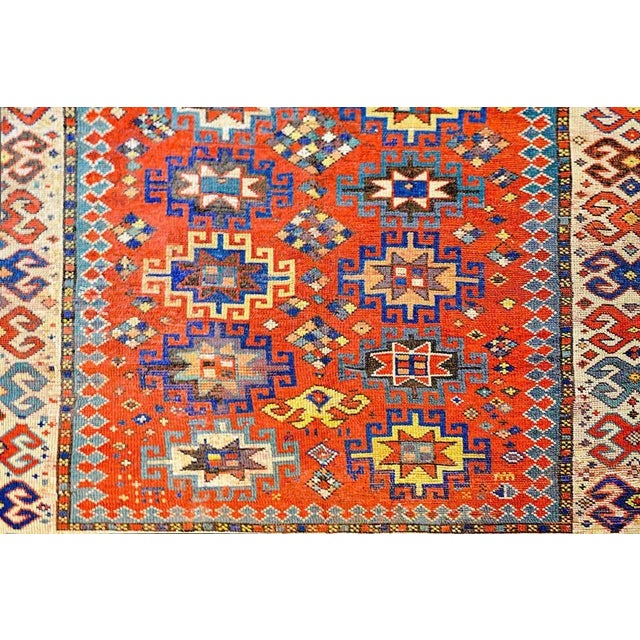 An outstanding early 20th century Lambalo Kazak rug with a beautiful crimson central field containing multiple geometric...