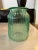 Vintage light green ribbed glass jar. There are 2 indented places where the glass was pinched for easy holding. This could...