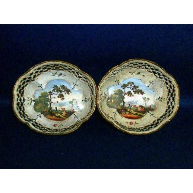 A beautiful pair of Battersea enamel baskets each painted with a landscape design in the center. Measure 3 1/2" x 3 1/8" x...