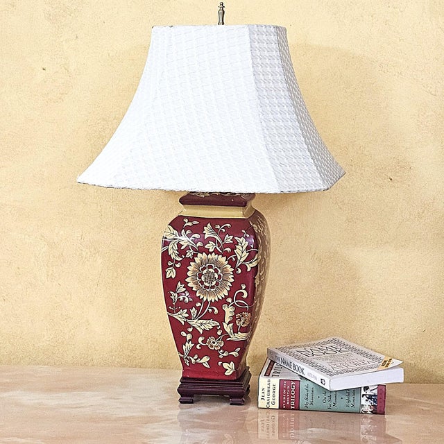 Vintage Chinoiserie-style porcelain table lamp with an elegant vase-form silhouette. The burgundy porcelain base is...