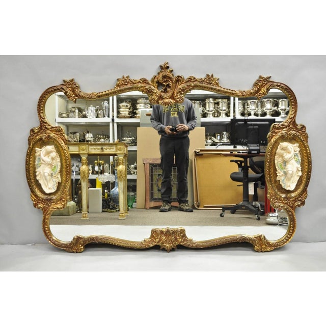 Vintage French Rococo Large Gold Wall Mirror with Bisque Figural "Lovers" Plaques. Item features an ornate gold molded...