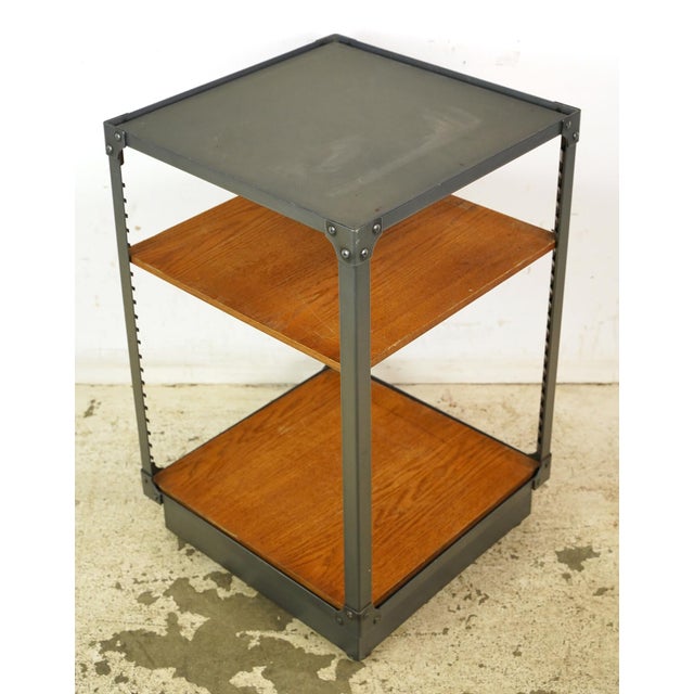 Reclaimed utility shelf made of gray painted steel and medium tone wood shelves. The one shelf piece is adjustable, and...