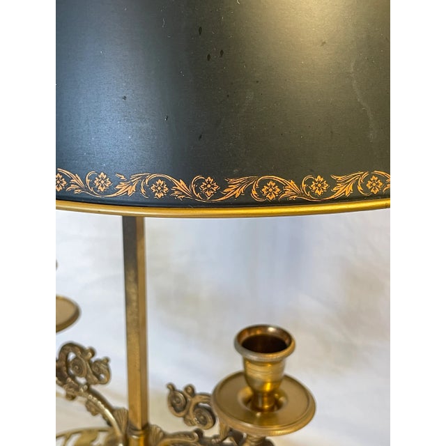Heavy bronze two light lamp with tole shade. Base is reticulated bronze; highly decorated candle arms. Gilt decoration on...