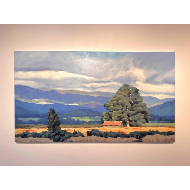 Under the Boughs captures a serene landscape where a solitary tree and a rustic cabin emerge amidst rolling hills and...