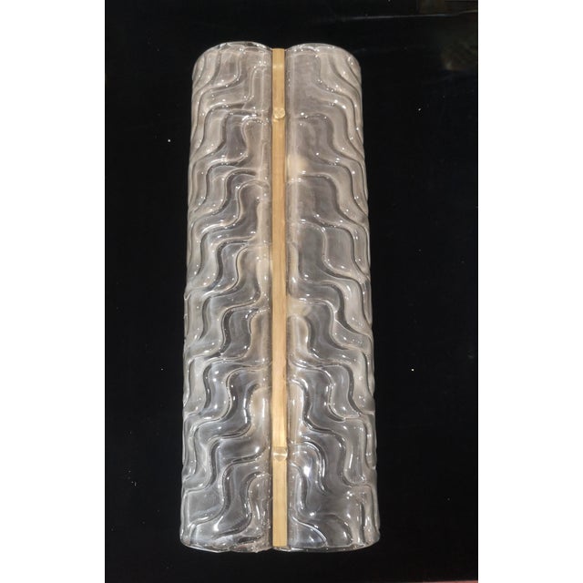 Refined and delicate design for this sandblasted Murano glass wall lamp. The wall lamp is made of a gold-colored metal...