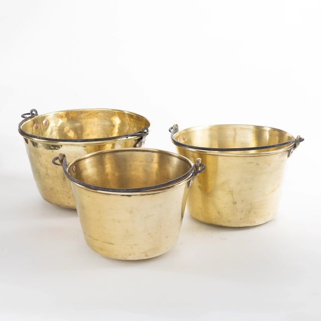 Assembled set of three spun brass kettles, (in various heights and graduated diameters 10-1/2”, 9-1/2” & 8-1/2”) with...