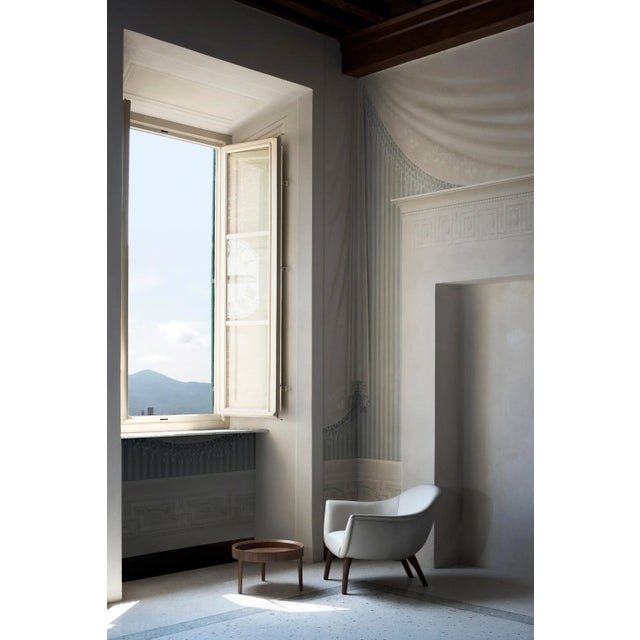 This versatile side table is made entirely of walnut-veneered plywood and features a circular top and three straight legs...