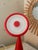 A distinctive IKEA FRYEBO table lamp in vibrant red, featuring an unusual sculptural silhouette, a conical base and a...