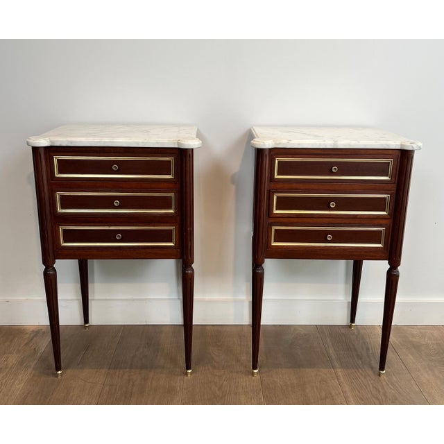 This beautiful and elegant pair of side or bedside tables is made of wood and brass with Carrara marble tops. These tables...