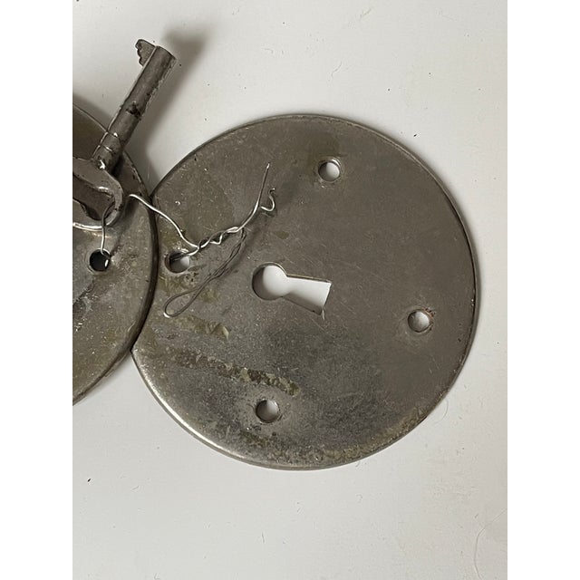 Round metal Art Deco keyhole plate with key.