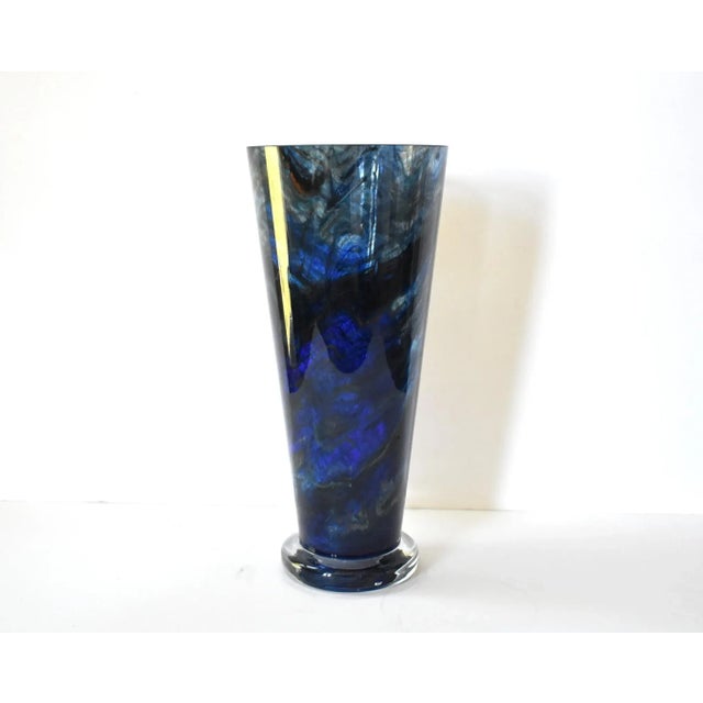 A vintage featherd, swirled, or marbled blue glass vase, probably mold blown, with a clear glass base, and cut glass top...