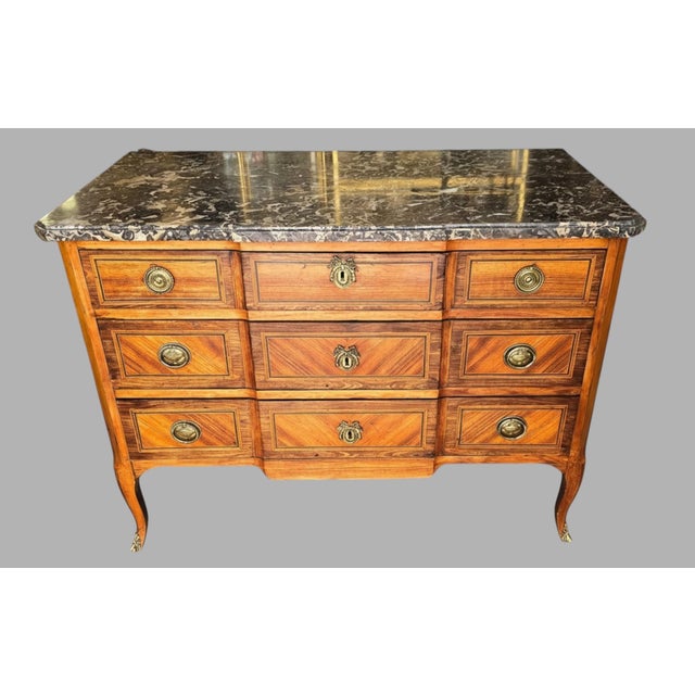 A louis xv–louis xvi transition period commode, circa 1770–1775, veneered with geometric marquetry. it opens with three...