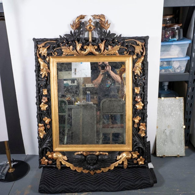 Gilded and ebonized oak Baroque style mirror. Meticulously restored with 23K gold leaf detailing.