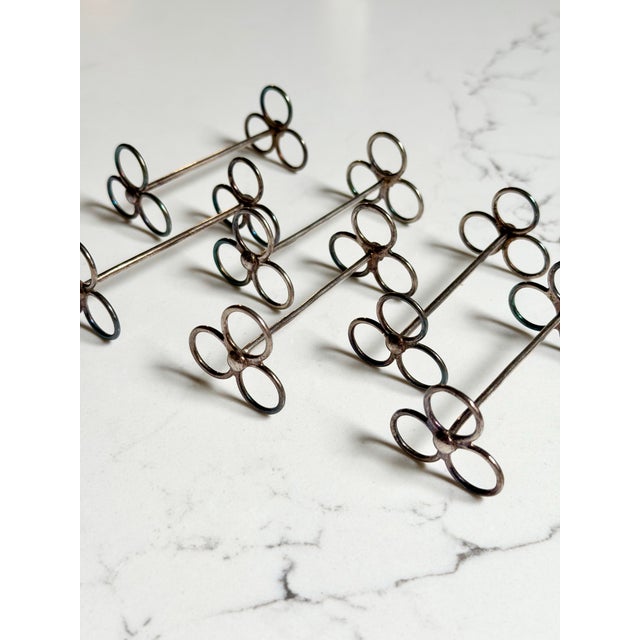 A stylish set of six silver plate knife rests in a classic trefoil form, designed in the elegant lines of the Art Deco...
