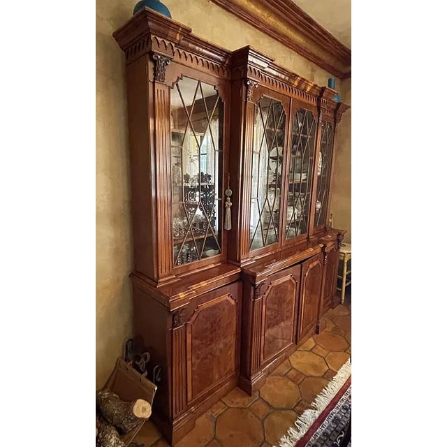 Elegant Baker Furniture breakfront China cabinet crafted in rich flame mahogany with a traditional Georgian / Chippendale-...