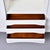 A refined Scandinavian Modern credenza featuring two sliding panel doors flanking a center open shelf above four drawers...