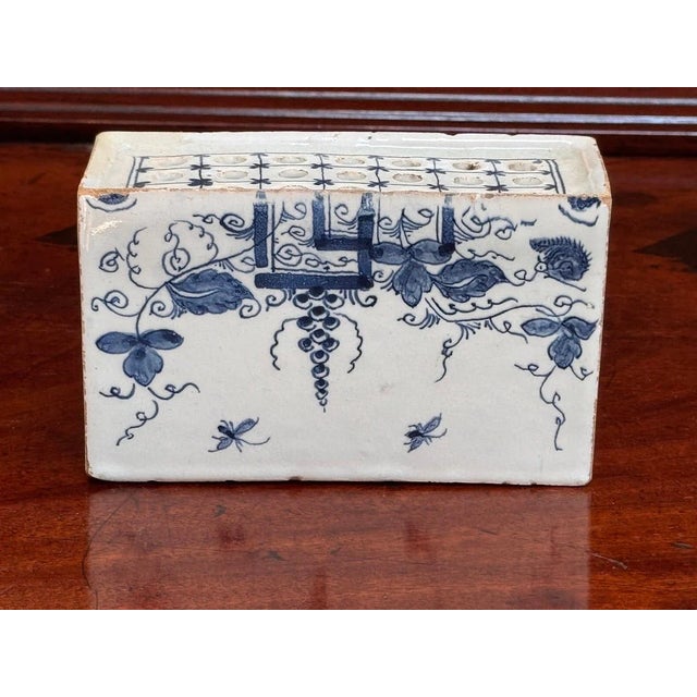 English Delft Flower brick, c. 1760. Having wisteria and insect decoration, 21 holes for flowers and a flat base. 3.5” h....