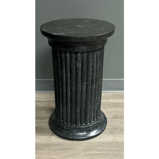 A black tesselated stone ionic column pedestal stand table perfect for a plant, sculpture or drink side table. Attributed...