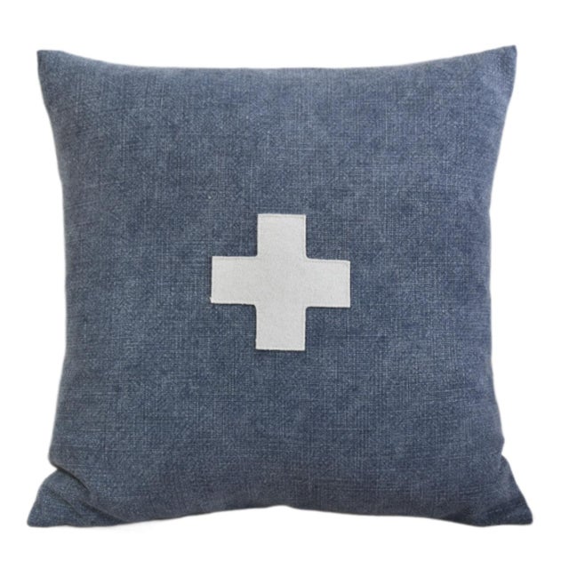 Custom-tailored pillow created from a blue woven cotton/linen textile. Pillow has a cream-colored wool appliqué cross on...