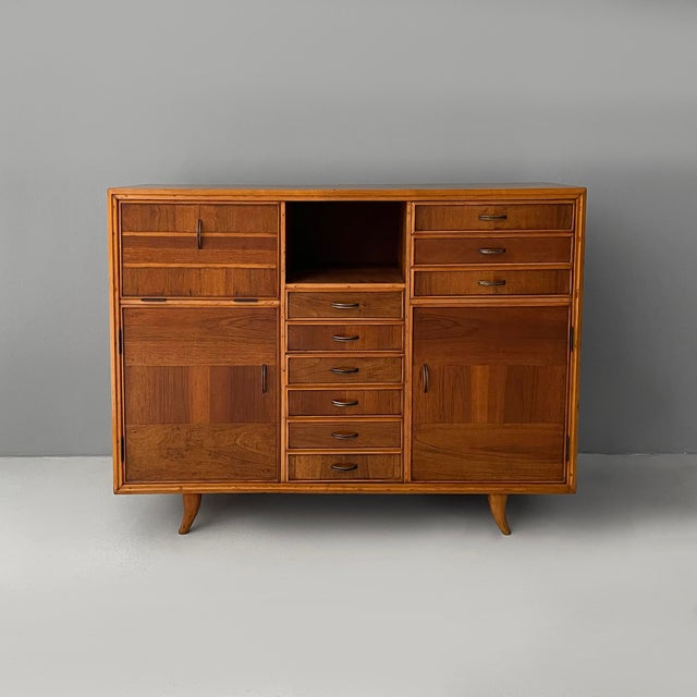 Italian mid-century modern sideboard in wood and brass, 1950s Rectangular wooden sideboard. The front features nine...