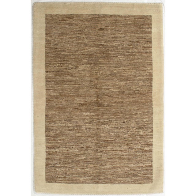 Vintage Hand-knotted Gabbeh rug featuring a softly textured brown field framed by a subtle ivory border. The tonal...