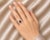 Elegant 14K white gold filigree ring featuring a natural emerald-cut garnet center stone weighing 1.4 carats, accented by...