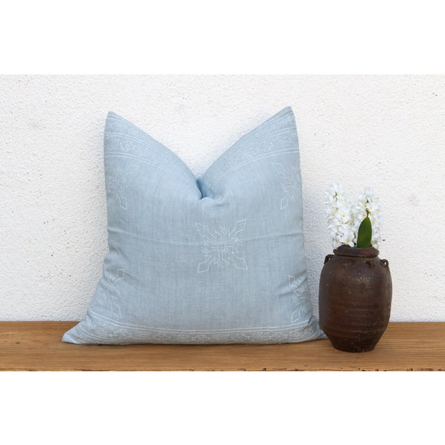 An eight-point star medallion, hand block-printed in white, traces softly across a powder blue linen ground on this pillow...