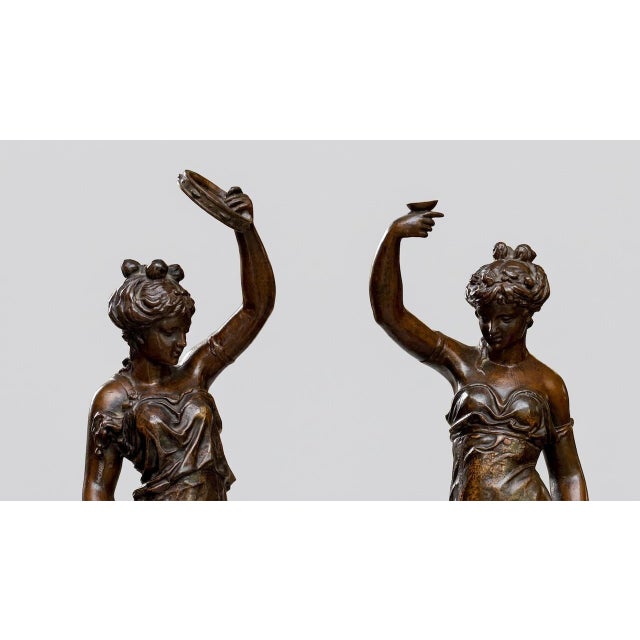 Pair of 20th-Century Bronze-Patinated Female Figurine Sculptures. A decorative pair inspired by the celebrated French...