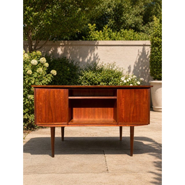 A beautifully designed Danish modern teak writing desk in the style of Arne Vodder, made in Denmark, circa 1960s. The desk...