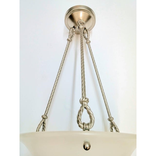 A French Art Deco pendant chandelier with a concave frosted glass or alabaster shade supported by four rods of rope design...