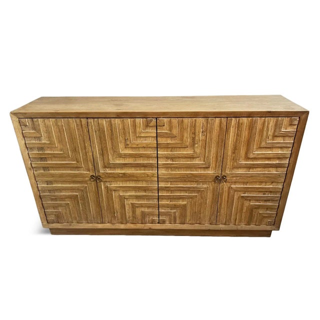 Vintage natural solid pine wood sideboard with geometric carved design on four doors. Slight washed finish. Opens up to...