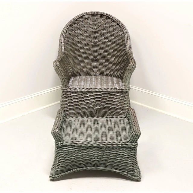 A Victorian style wicker armchair and ottoman, unbranded. Gray painted woven wicker reed and wood under frame. Chair...