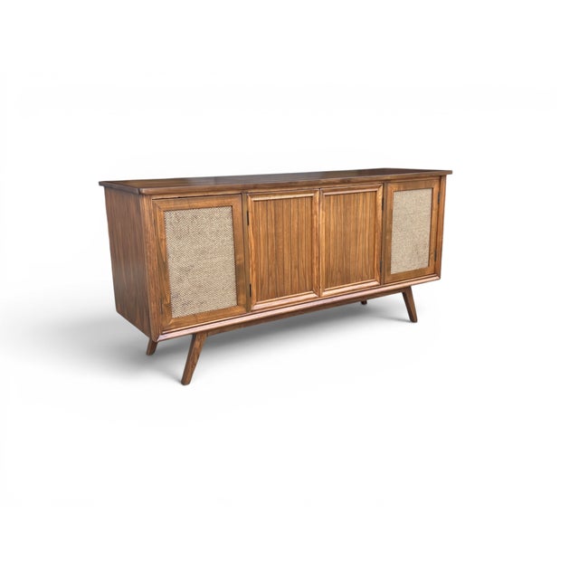 A striking blend of iconic Mid-Century Modern design and exceptional craftsmanship, this restored walnut stereo console is...