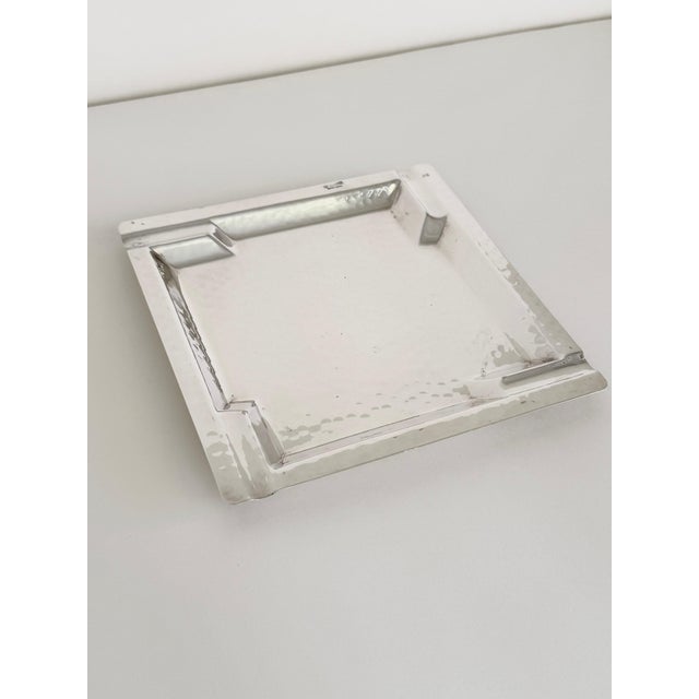 A large square silver-plated ashtray by Castelli, Italy, circa 1970s. The ashtray features a hand-hammered surface...