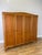 A substantial Vintage French Louis wardrobe in oak, featuring four tall panelled doors, a gently shaped cornice, curved...