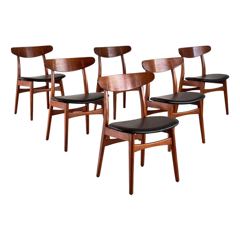 Six wooden chairs with black seats