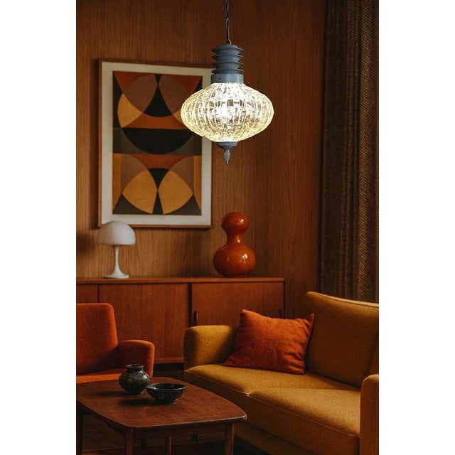 A striking Danish Mid-Century Modern pendant light, combining a beautifully textured opalescent glass globe with warm...