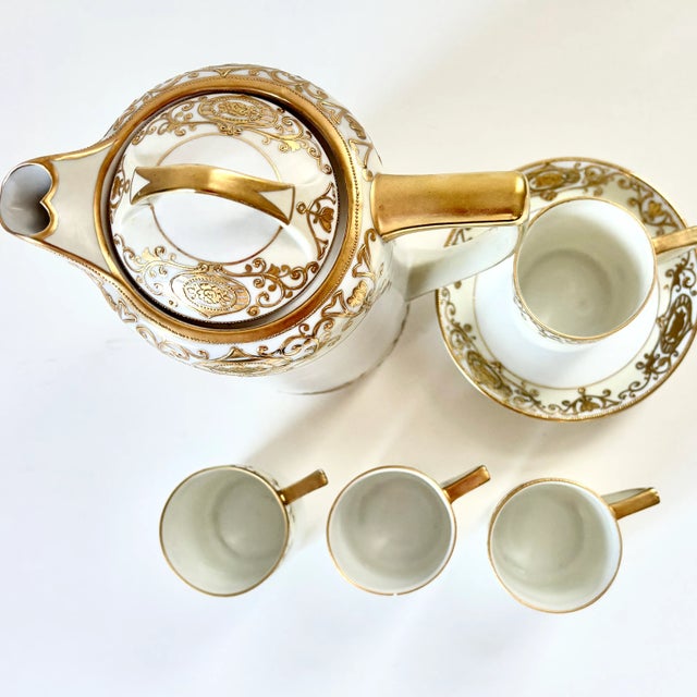 This lovely Nippon hand-painted porcelain demitasse set with gold filigree is fit for royalty. The set includes a tall pot...