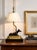 A sculptural vintage table lamp featuring a sleek bronze-tone greyhound or whippet reclining atop a stepped gilt plinth,...