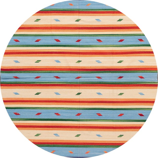 A beautiful hand-woven modern Kilim rug with a tan field and multi-color accents in an all-over stripe design. This rug...