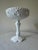 A lovely vintage milk glass compote with beautiful embossed detail, circa 1950s–60s. The wide scalloped bowl features...