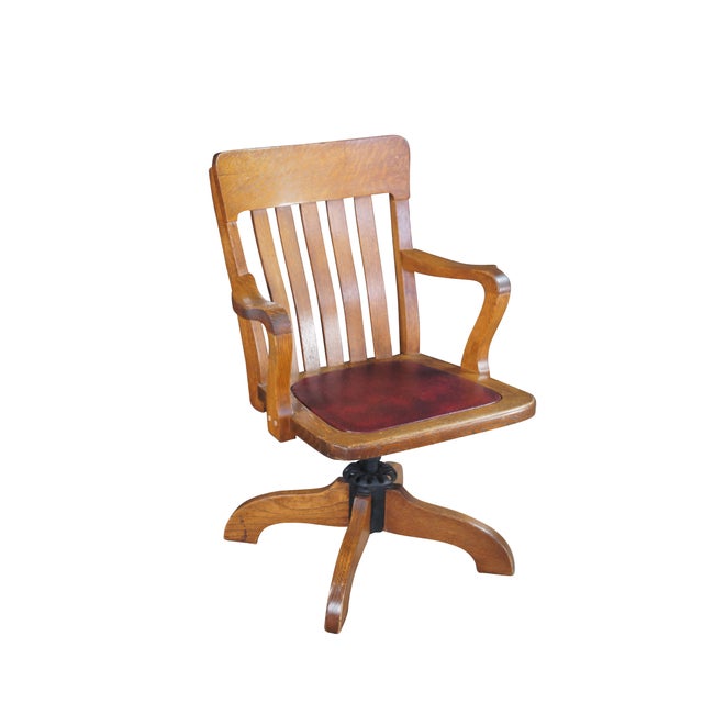 Charming Edwardian Era Desk Chair, circa 1900s. Features a quartersawn oak frame with a slat back, contoured arms and a...